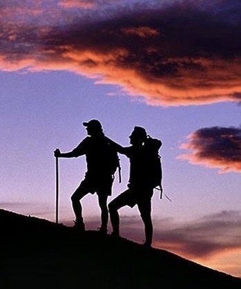2 hommes qui montent ensemble une montagne avec l'un qui devance puisqu'il est le guide comme un coach